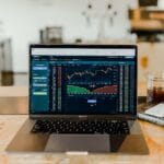 Laptop On Table Showing Stock Trading